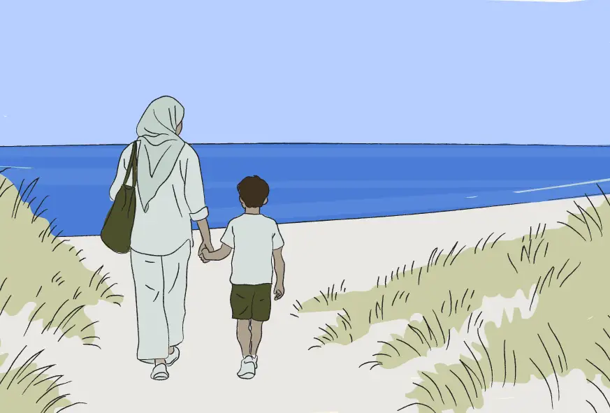 Huda og hendes søn der går på stranden mod havet