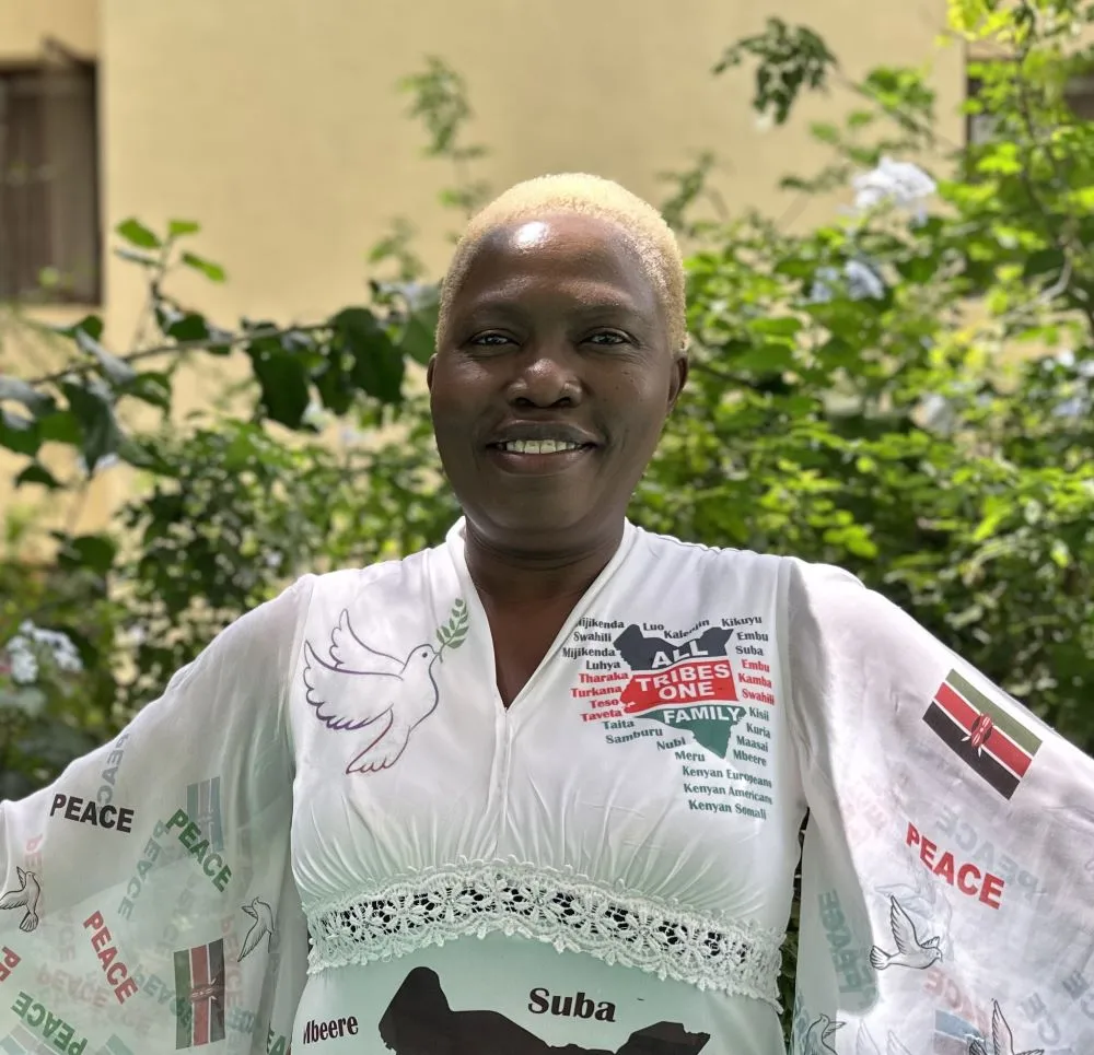 Mama Peace smiling with her white peace dress on
