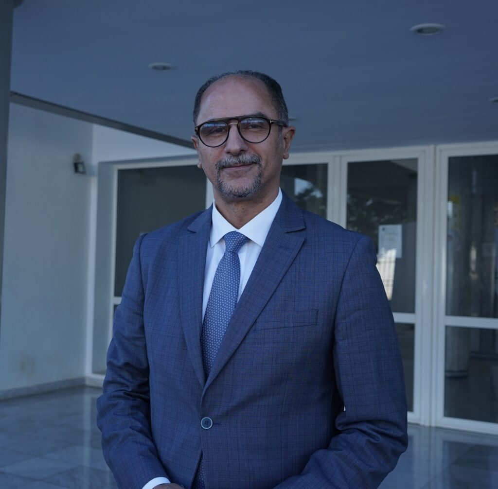 Mohammed Bouzlafa in a suit in front of the university